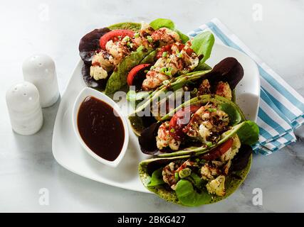 tachicchi verdi di vegano senza glutine a base di farina di ceci con spinaci e condimenti a base di cavolfiore al forno e lattuga con salsa dolce e acide a base di o Foto Stock