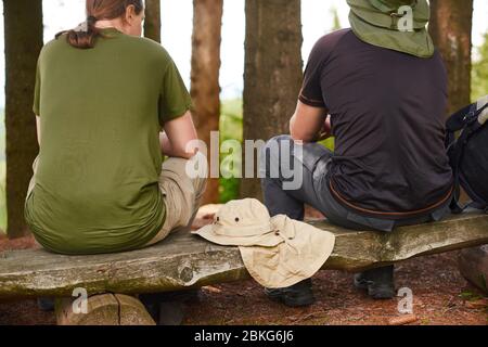 i turisti siedono sul ceppo che vediamo le loro spalle Foto Stock