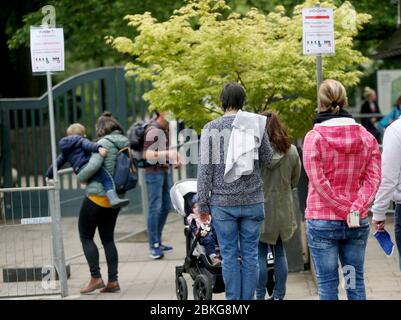 Krefeld, Germania. 04 maggio 2020. Di fronte allo zoo di Krefeld, piccoli gruppi di visitatori attendono alla biglietteria con la distanza necessaria. Ad oggi non solo musei e scuole di musica, ma anche giardini zoologici sono aperti di nuovo. Credit: Roland Weihrauch/dpa/Alamy Live News Foto Stock