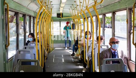 Roma, Italia, 04/05/2020, persone che indossano maschere facciali occupano posti designati su un tram a Roma il primo giorno di relax nelle misure di blocco totale in vigore in Italia tra l'11 marzo e il 3 maggio. Foto Stock