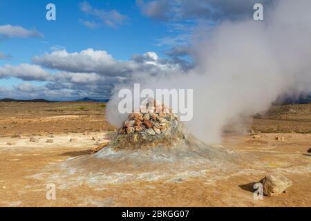 Un mucchio di pietra sopra una bocca di vapore nella zona geotermica di Námafjall (chiamata anche Hverir), Islanda. Foto Stock