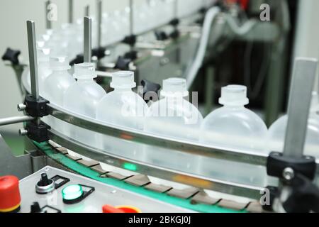 industria farmaceutica, pillole di medicina stanno riempiendo la bottiglia di plastica sul trasportatore della macchina della linea di produzione presso la fabbrica medica. Riempimento della fiala Foto Stock