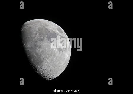 La fase lunare di Gibbous cercarsi come visto dall'emisfero settentrionale con la luna appoggiata contro un cielo nero chiaro della notte Foto Stock