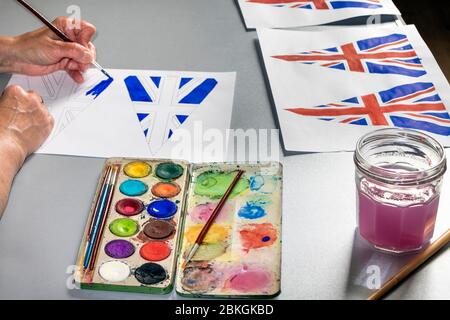 Woman Painting 75th Anniversary VE Day Flags, UK Foto Stock