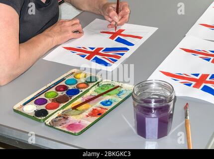 Woman Painting 75th Anniversary VE Day Flags, UK Foto Stock