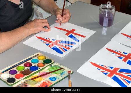 Woman Painting 75th Anniversary VE Day Flags, UK Foto Stock