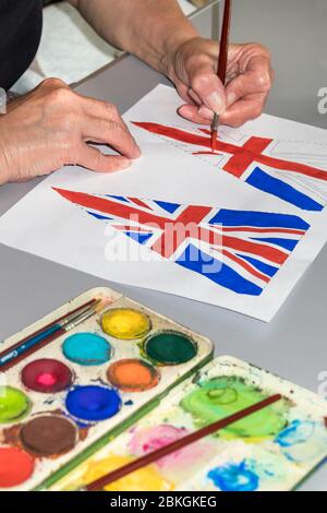 Woman Painting 75th Anniversary VE Day Flags, UK Foto Stock