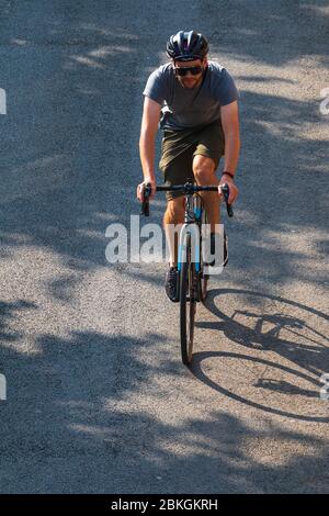 Un uomo fuori per un giro di mattina presto su una bici di strada a York, Regno Unito. Foto Stock