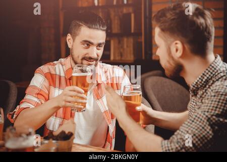 Festa in pub, bicchieri di birra in agguato, divertente ridere amici. Foto Stock