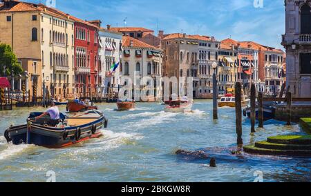 Venezia, Provincia di Venezia, Regione Veneto, Italia. Traffico sul Canal Grande. Barche di consegna. Taxi acquatici. Venezia è un sito patrimonio dell'umanità dell'UNESCO. Foto Stock