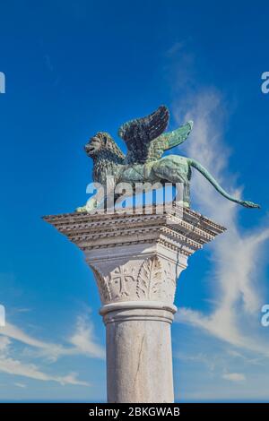 Venezia, Provincia di Venezia, Regione Veneto, Italia. Il Leone di Venezia alato di bronzo si erge sulla sua colonna di granito nella Piazzetta a pochi passi da Piazza San ma Foto Stock