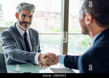 Uomini d'affari si stringono la mano in ufficio Foto Stock