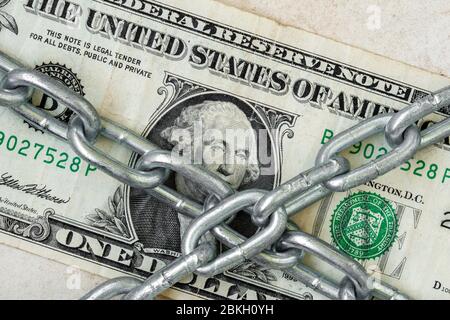 Primo piano del dollaro USA sotto catena metallica. Corruzione negli Stati Uniti. Sicurezza finanziaria, crisi economica, investimenti aziendali, moneta e protezione del denaro co Foto Stock
