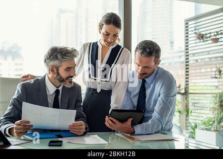 Sorridente business persone che lavorano in ufficio Foto Stock