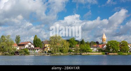 Panorama del Lago di Wessling (Weßlinger See). Con caratteristico bulbo torre della chiesa cattolica 'Christkönig'. Cielo blu con nuvole. Foto Stock