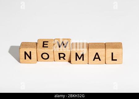 Nuovo concetto normale. Dadi in legno con testo isolato su sfondo bianco. Spazio di copia Foto Stock