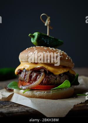 hamburger fresco e gustoso su vecchio tavolo di legno scuro Foto Stock