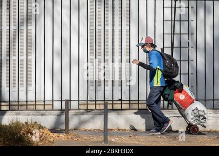 Persone reali preoccupate, protette con maschere e a piedi che trasportano borse di shopping nelle strade di Providencia durante la malattia di infezione da coronavirus COVID-19 Foto Stock