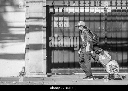 Persone reali preoccupate, protette con maschere e a piedi che trasportano borse di shopping nelle strade di Providencia durante la malattia di infezione da coronavirus COVID-19 Foto Stock