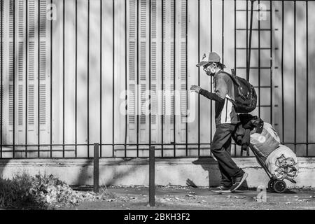 Persone reali preoccupate, protette con maschere e a piedi che trasportano borse di shopping nelle strade di Providencia durante la malattia di infezione da coronavirus COVID-19 Foto Stock