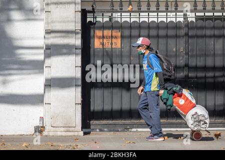 Persone reali preoccupate, protette con maschere e a piedi che trasportano borse di shopping nelle strade di Providencia durante la malattia di infezione da coronavirus COVID-19 Foto Stock