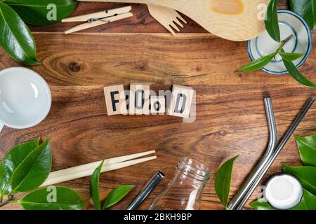 Il mattone di legno con le parole 'CIBO' su sfondo di legno. CONCETTO ECO con simbolo di riciclaggio e foglie. Foto Stock