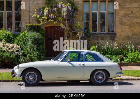 Un classico MGB GT anni '70 parcheggiato in un villaggio Cotswold, Inghilterra Foto Stock