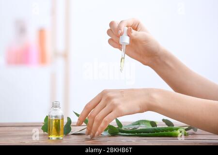 Donna che applica olio essenziale sulle sue mani Foto Stock