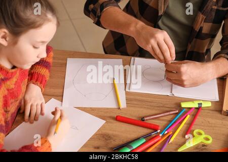 Insegnante di disegno che dà lezioni facoltative a scuola Foto Stock