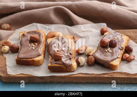 Pane fresco e pasta di cioccolato e noci a bordo Foto Stock