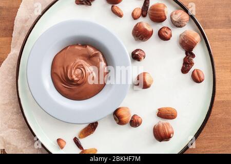 Piatto con gustosa pasta di cioccolato e noci sul tavolo Foto Stock