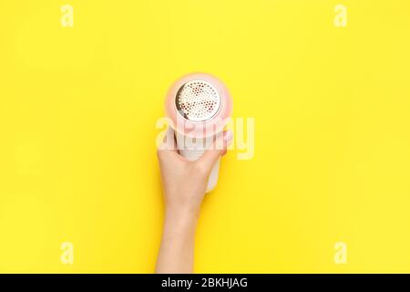 Mano femminile con moderno rasoio in tessuto su sfondo colorato Foto Stock