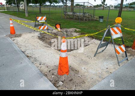 Buca nella strada, cantiere, bloccato da coni arancioni, barricate e nastro di attenzione - Pembroke Pines, Florida, USA Foto Stock