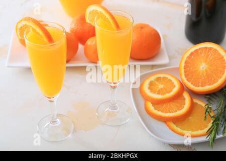 Bicchieri di gustosi cocktail mimosa al tavolo Foto Stock