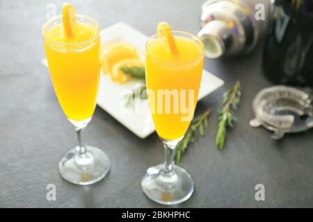 Bicchieri di gustosi cocktail mimosa al tavolo Foto Stock