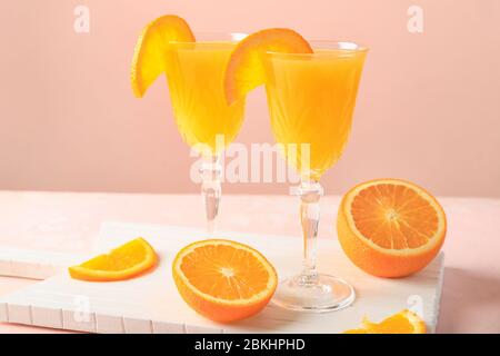 Bicchieri di gustosi cocktail mimosa al tavolo Foto Stock
