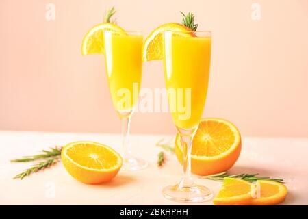 Bicchieri di gustosi cocktail mimosa al tavolo Foto Stock