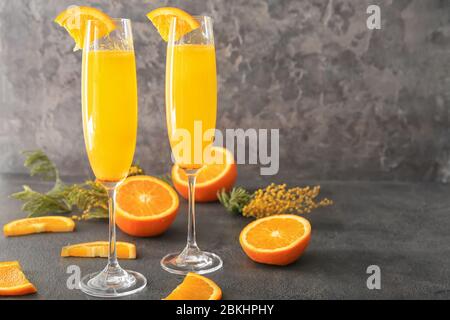 Bicchieri di gustosi cocktail mimosa al tavolo Foto Stock