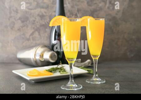 Bicchieri di gustosi cocktail mimosa al tavolo Foto Stock