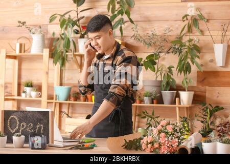 Fioraio asiatico maschile che lavora in negozio Foto Stock