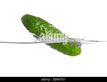 Caduta di cetrioli freschi in acqua su sfondo bianco Foto Stock