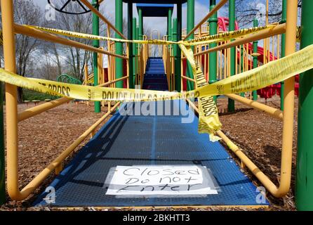 Chiuso non entrare segno con la linea di polizia non attraversare barricata nastro circonda un impianto di gioco scuola elementare durante il blocco di Covid-19, pandemia coronavirus in New Jersey.USA Foto Stock