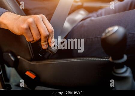 Concetto di guida di sicurezza. Un uomo fissa la cintura di sicurezza. Prima di guidare Foto Stock