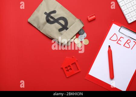 Borsa con denaro, calcolatrice, modello di casa e carta con debito di parola su sfondo a colori Foto Stock