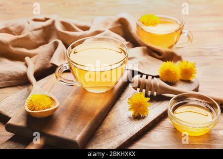 Tazza di tè di dente di leone sano con miele sul tavolo Foto Stock