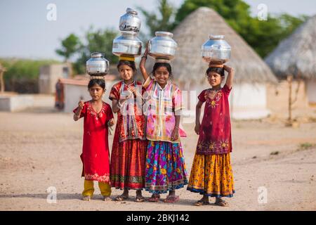 India, Gujarat state, regione di Kutch, villaggio di Ludiya, vicino a Bhuj, gruppo di ragazze di Meghwal che trasportano i vasi di acqua potabile sulla loro testa Foto Stock