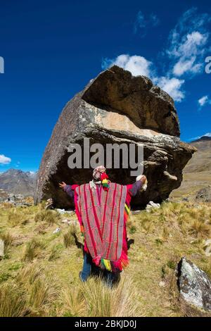 Perù, Cusco, Mahuayani, Cordillera de Sinakara, comunità indigena Q'ero, clan Quiko, sacerdote della religione andina Lorenzo si rivolge al Pachamama, ai piedi della roccia sacra, o huaca, per cercare buoni auspici Foto Stock