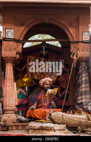 India, Rajasthan, kolayat, sadhu lettura sotto un arco Foto Stock