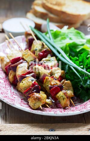 Kebab di pollo con verdure servite con varie erbe e salsa. Foto Stock