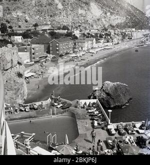 1960, storico, affacciato sulla piscina all'aperto del famoso Caleta Palace Hotel sulla baia Catalana e sulla costa della roccia di Gibilterra, una cresta calcarea su Gibilterra, un territorio britannico d'oltremare sul promontorio della costa meridionale della Spagna. Foto Stock